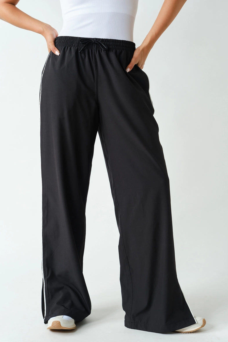 Black wide-leg track pants with drawstring waist and white piping